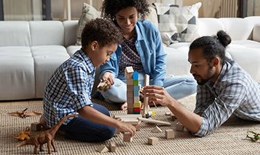 Family playing on a carpet refreshed with OxiClean™ Carpet and Area Rug Stain Remover Spray.
