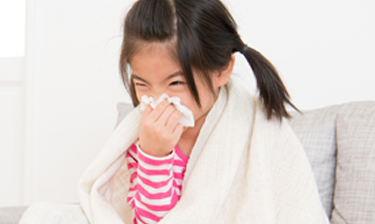 Girl wiping her nose on her sweatshirt