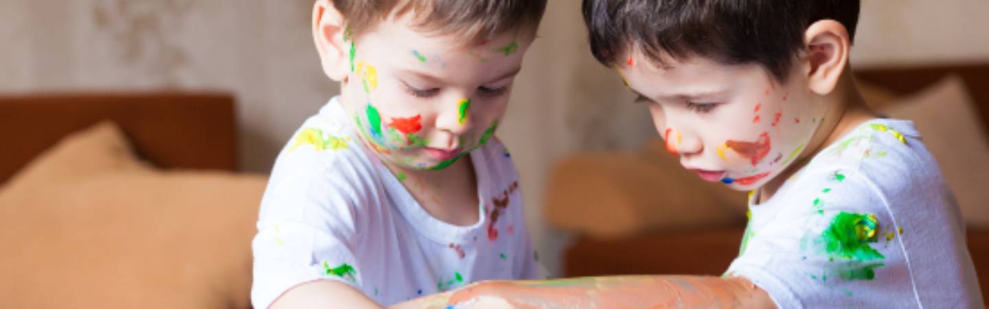 Kids playing with finger paints.