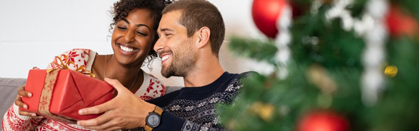 Couple exchanging holiday gifts. 