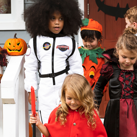 Kids trick or treating in costume on Halloween.