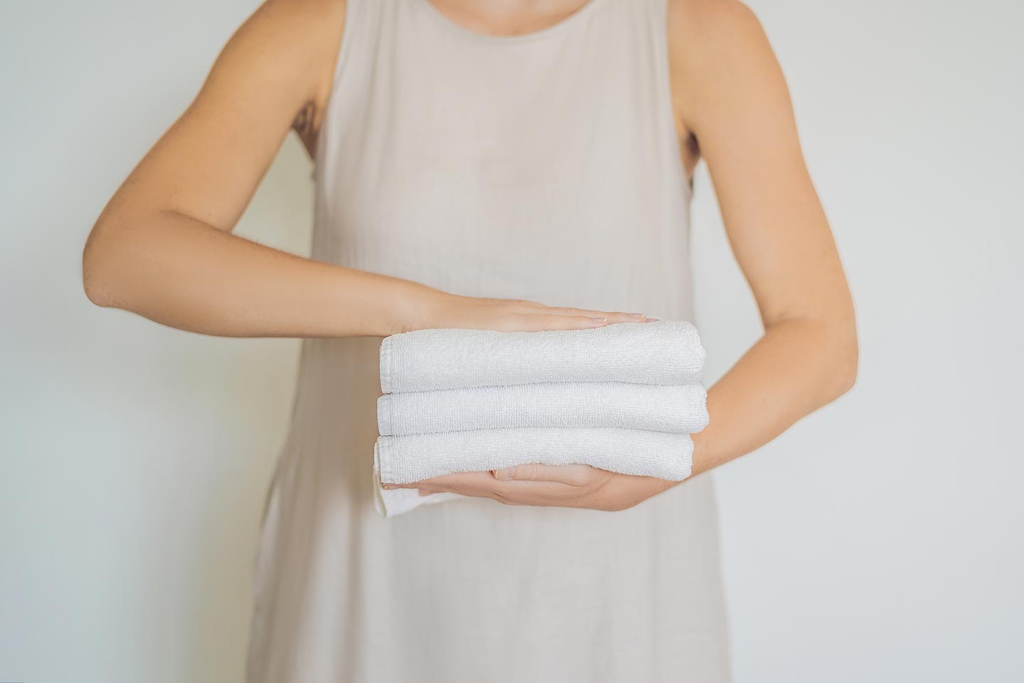 Person holding folded white towels