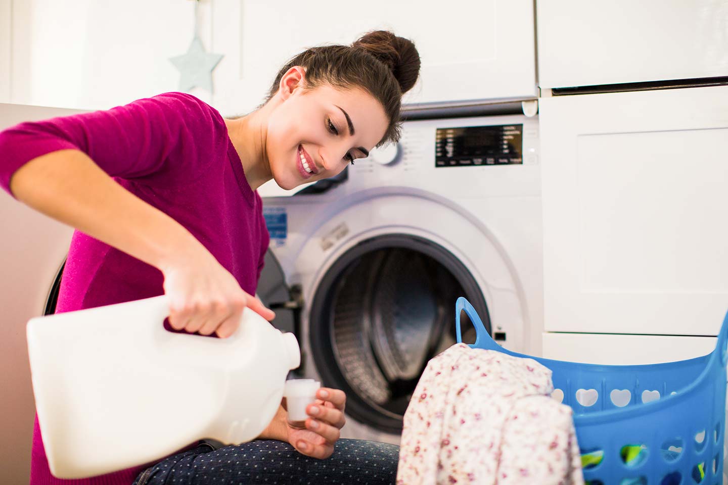 Woman pouring laundry detergent