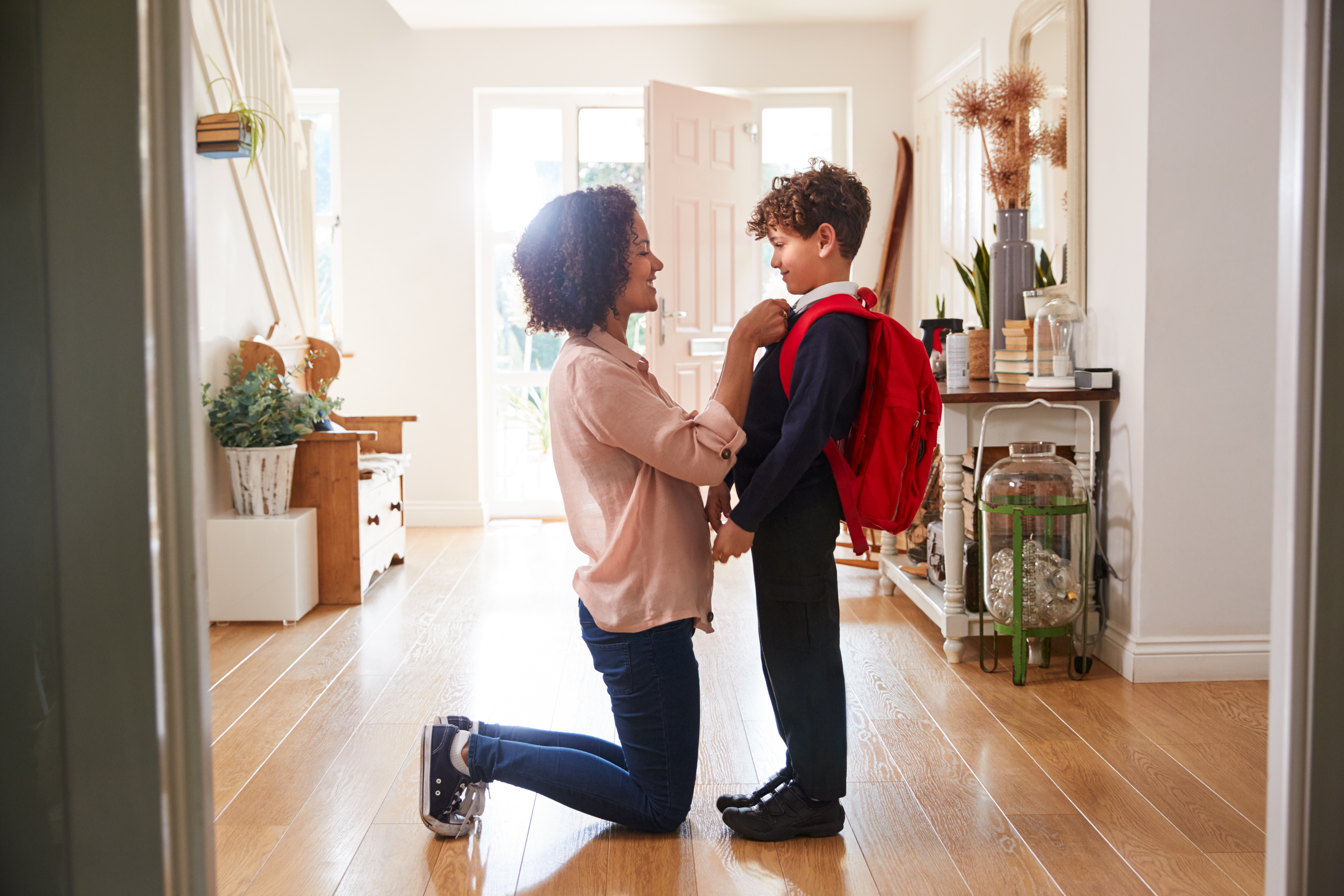 Mom helping son get dressed for school