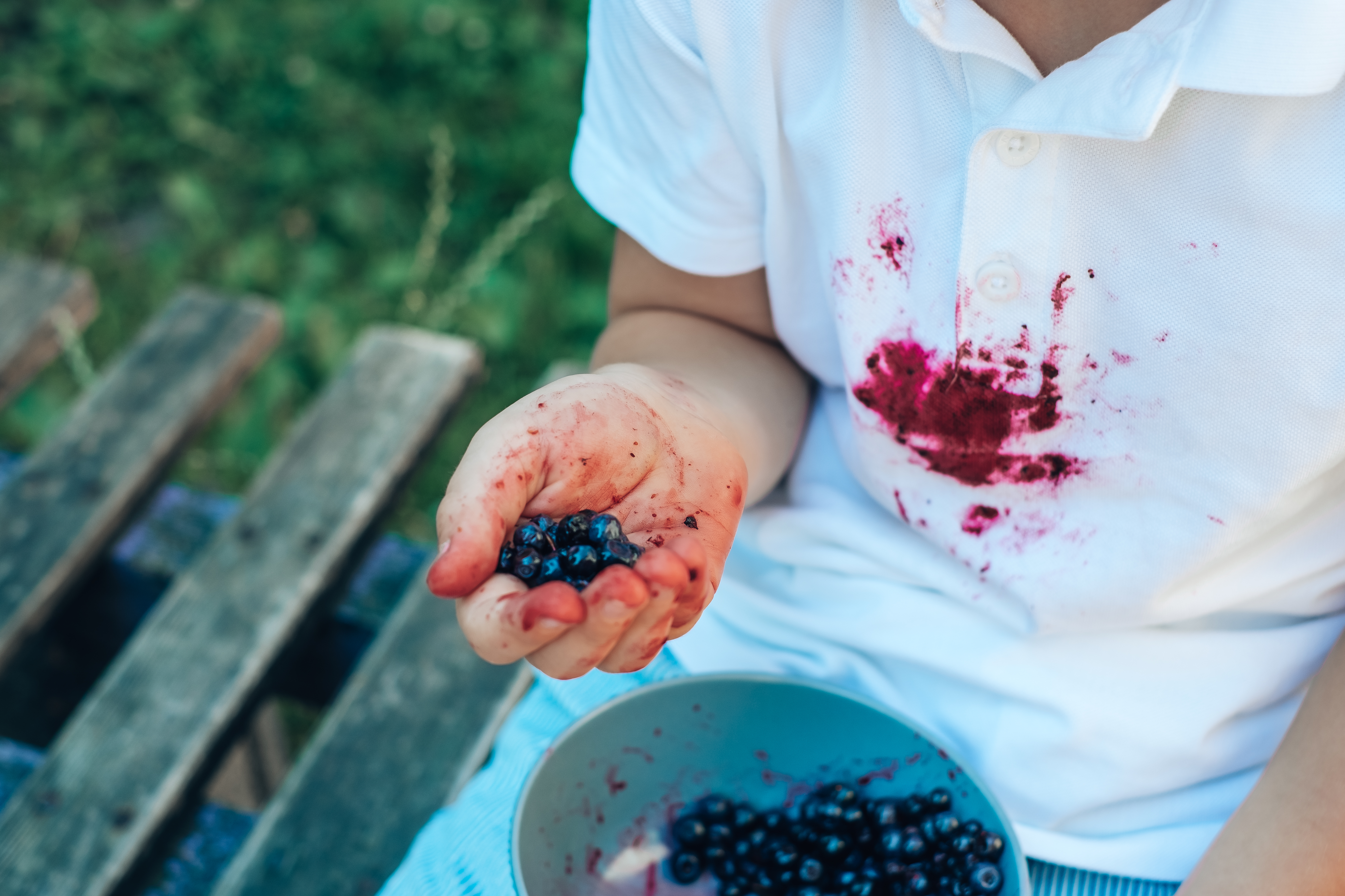 Person with blueberry stain on white shirt