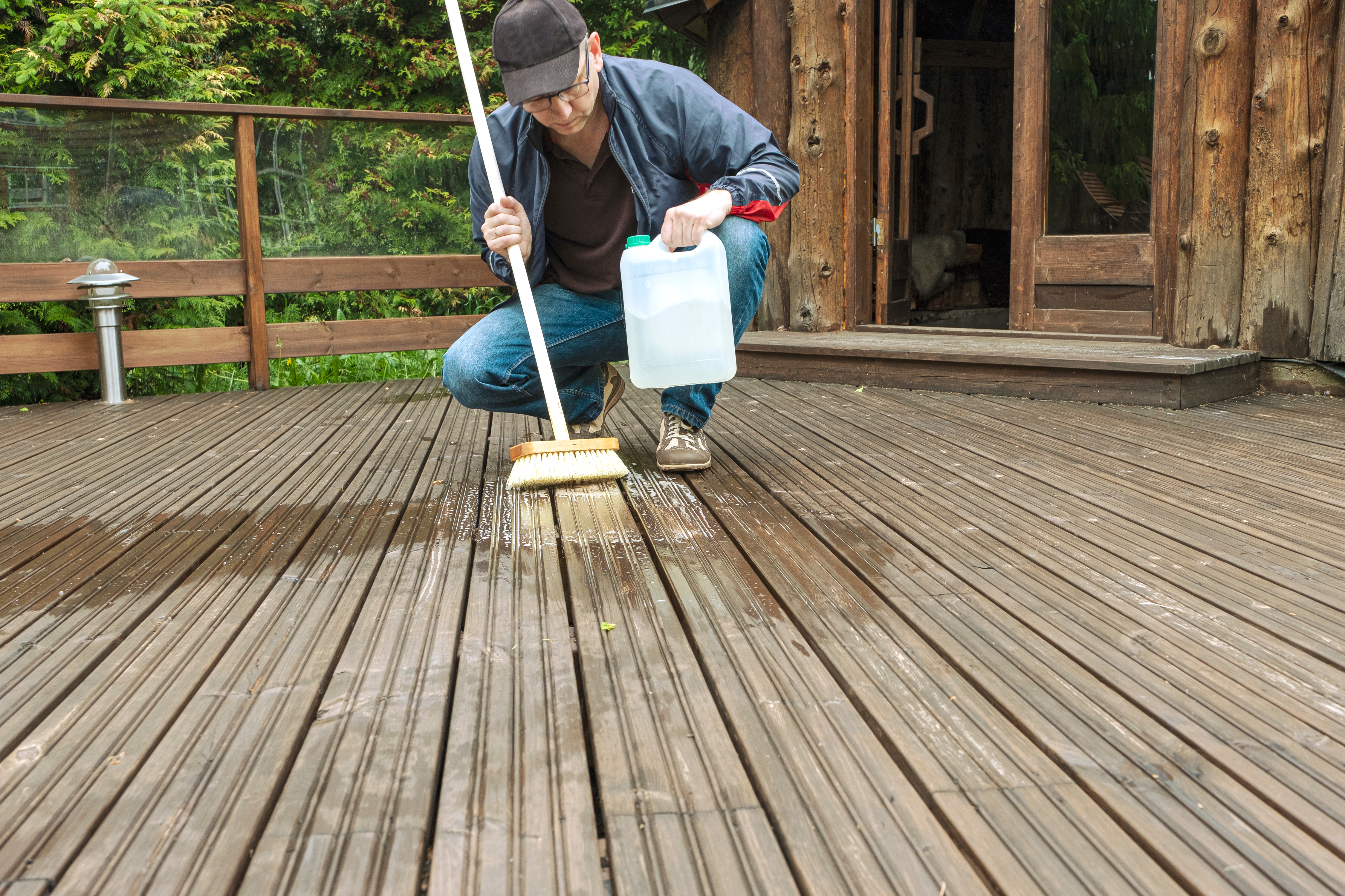 Person cleaning deck with broom