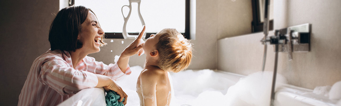 Mom and son playing during bath time.