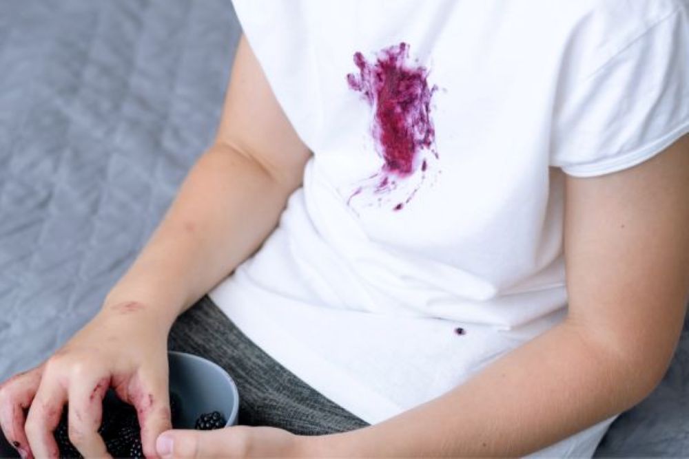Dark berry stains on a child’s white t-shirt.